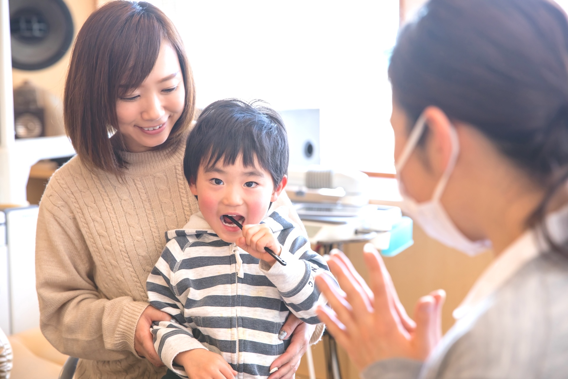 小さなお子様に歯磨き指導をしている様子の写真